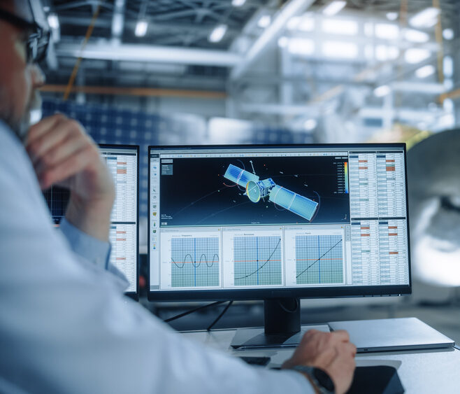 space simulation systems engineer with satellite on screen